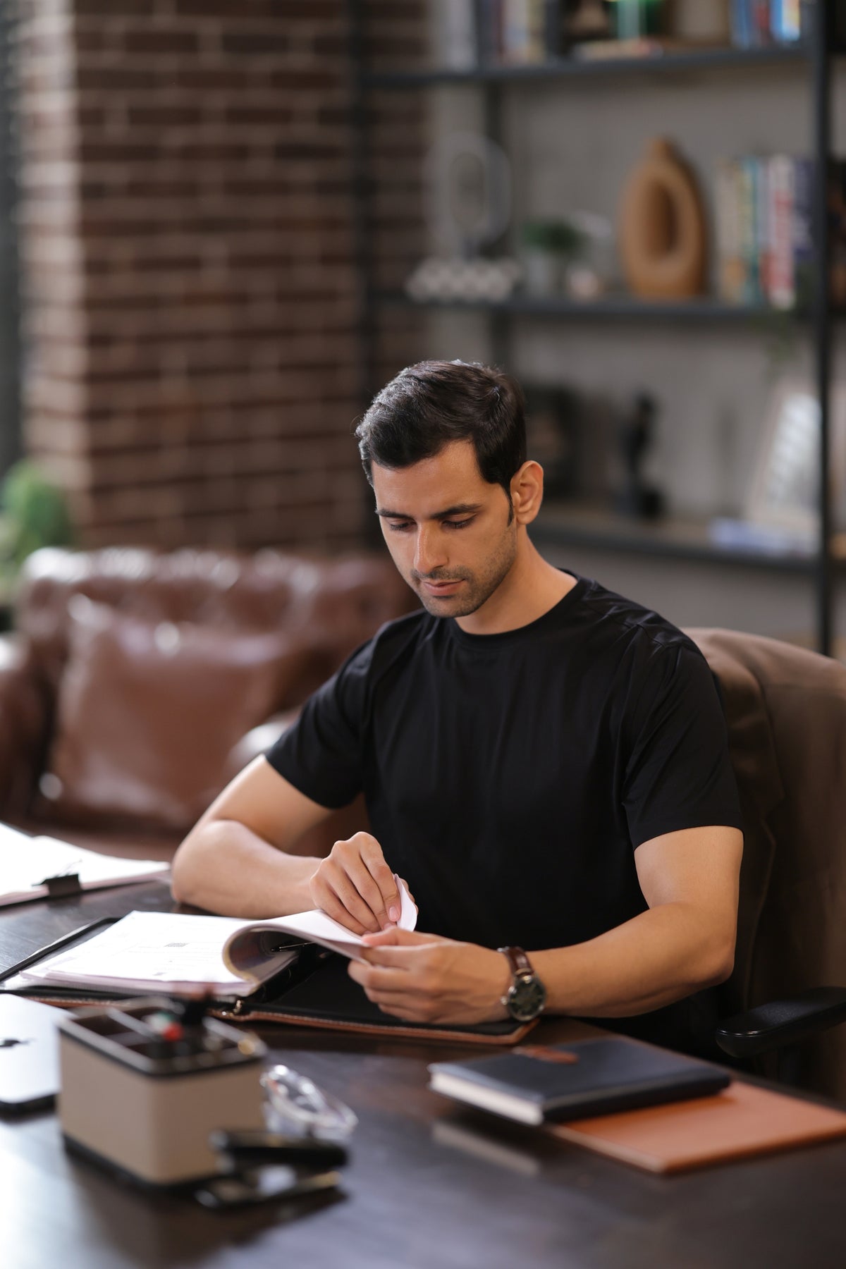 Man in a black T-shirt at a desk