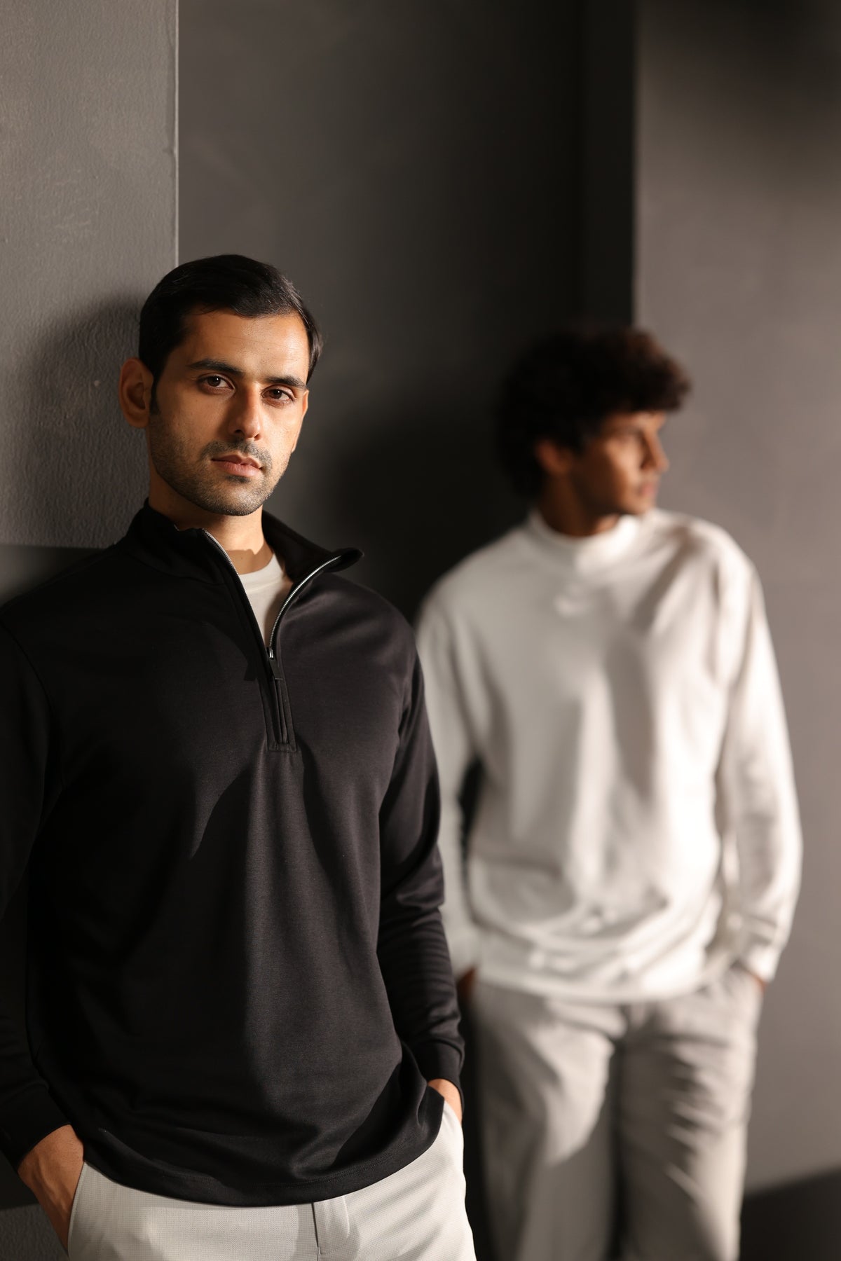 Two men wearing black and ivory essentials